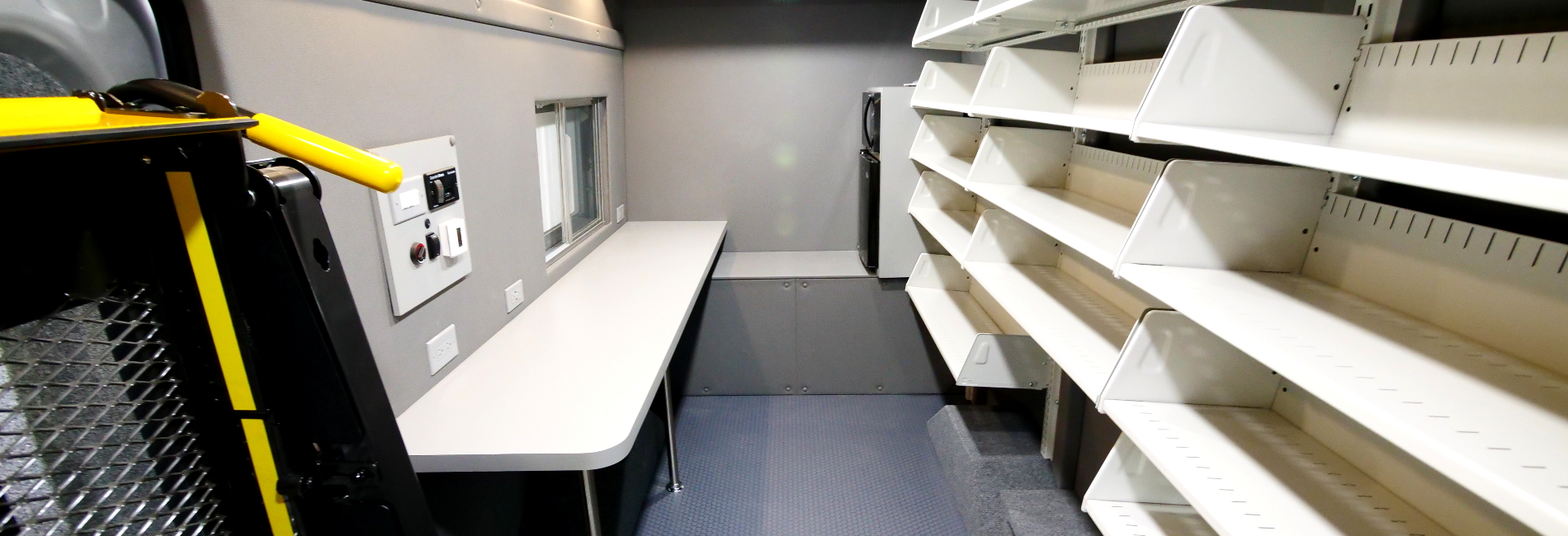 Library bookmobile that is capable of holding vast assortment of books with a lift, sliding window, and workstation.