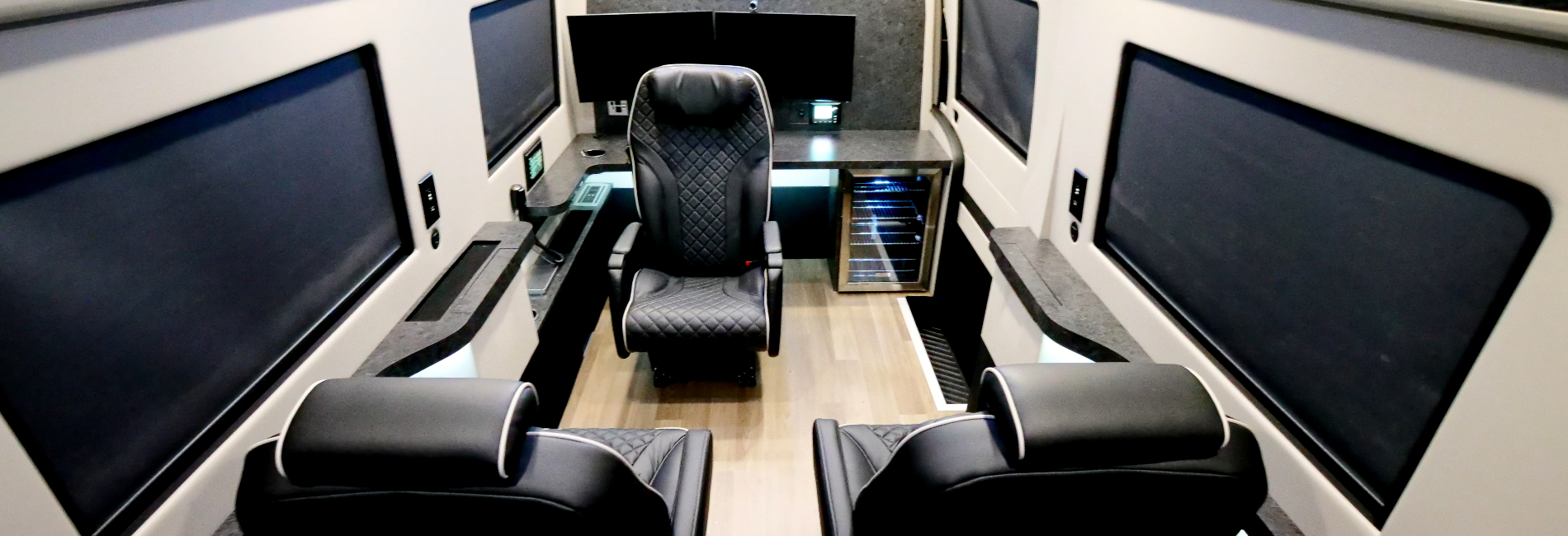 Executive mobile office featuring a multi-functional boardroom with a complete workstation, captain seating, and full electronic integration.